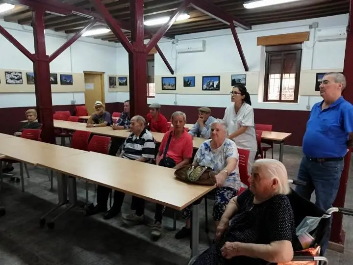 La terapeuta ocupacional junto a los once residentes en la exposicioin de Alonso de la Calle