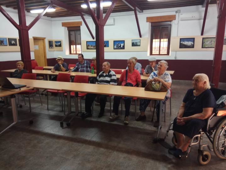 Los mayores atiendes las explicaciones en la exposicion sobre la cabra montesa